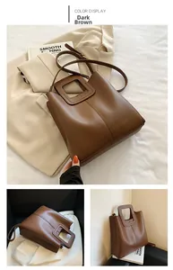 Detail view of deep brown faux leather tote with minimalist hollow handle and strap