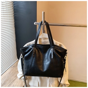 Détails des rivets en forme d'étoile argentée sur le grand sac cabas noir en cuir mat