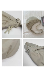 Detailed close-up of nylon crescent bag showing zippers and adjustable fabric strap