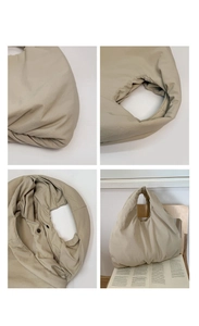 Dettaglio della borsa hobo imbottita beige che mostra il bottone e il nylon testurizzato