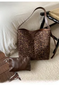 Detail der Totebag mit Leopardenmuster und braunem Etui auf einem Teppich in Wohnumgebung