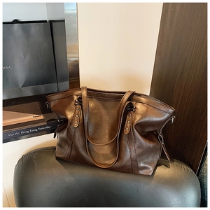 Détail du sac cabas marron foncé avec rivets en étoile et texture en similicuir huilé