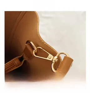 Detail of high-quality golden metal buckle and polished hardware on a brown leather bag