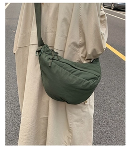 Detailed view of the dark green crescent bag showing the nylon fabric and curved seams