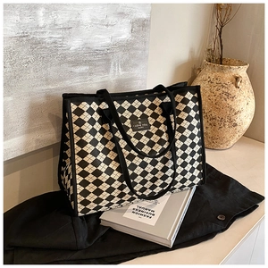 Detailed view of black and white checkerboard canvas tote bag with woven handles