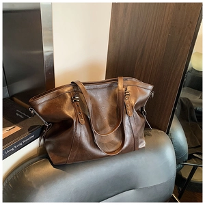 Détail du cabas vintage marron avec clous étoilés et texture en cuir lisse