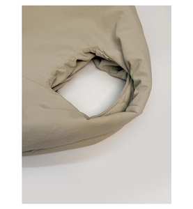 Close-up of beige pleated tote bag showing handle stitching and premium nylon fabric texture