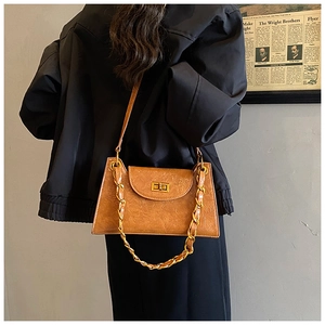 Detail of vintage camel faux leather crossbody bag with gold chain and metal clasp