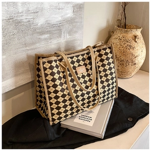Detailed view of checkered tote bag with woven handles and vintage leather patch logo