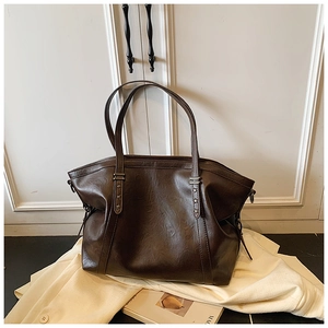 Détail du sac cabas en similicuir marron avec rivets métalliques en forme d'étoile