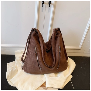 Détail du grand sac cabas marron mat avec doubles fermetures éclair sur texture suédine