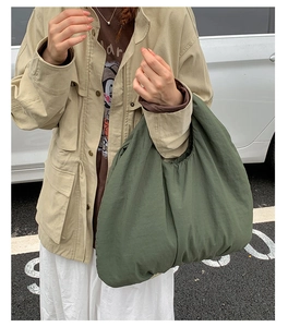 Dettaglio di una capiente borsa tote verde scuro in tessuto morbido stile urbano