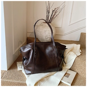 Détail du grand sac cabas marron foncé en similicuir brillant avec rivets en étoile