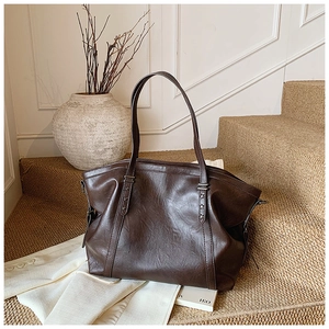 Détail du sac cabas marron vintage avec rivets en étoile sur la bandoulière en cuir