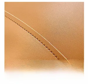 Macro shot of premium brown leather texture with precise stitching on a bucket bag