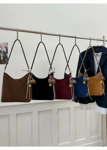 Detail view of suede shoulder bags in five colors with tassel and smile charms