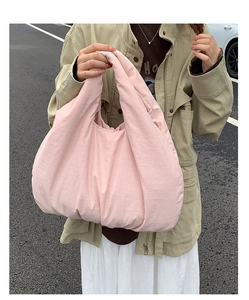 Detailed view of pink puffy tote bag showing high-quality nylon texture in daily use