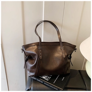 Détail de cabas marron foncé avec clous en forme d'étoile argentée et texture vintage