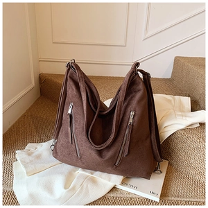 Détail du sac cabas en daim marron avec doubles fermetures éclair et grande capacité
