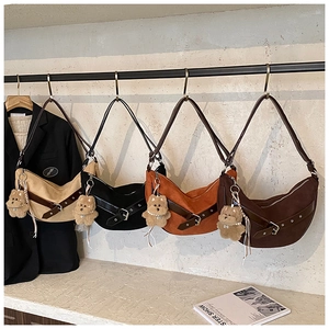 Row of four colorful hobo bags with decorative buckle straps and cute plush puppy charms