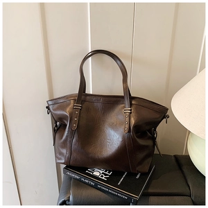 Détail du sac cabas marron foncé avec rivets en forme d'étoile et similicuir rétro
