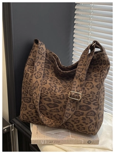 Close-up of leopard print tote bag with adjustable strap and gold metal hardware