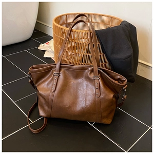 Détail du sac fourre-tout marron vintage avec rivets en étoile et bandoulière amovible