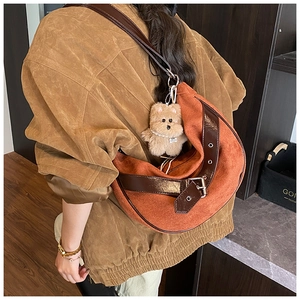 Detail view of suede leopard print crossbody bag with plush bear charm and metal eyelet strap
