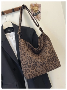 Detailed view of leopard print hobo bag hanging on a hook with stylish autumn accessories