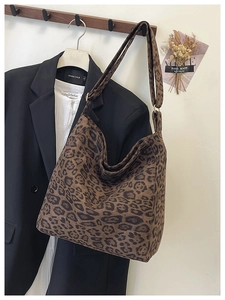Detail of vintage leopard print tote bag hanging on a suit with a minimalist background