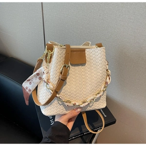 Detail of woven bucket bag with silk scarf chain and brown leather shoulder strap