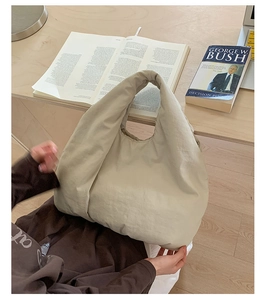 Detailed view of spacious beige puffer hobo bag showing its soft nylon texture and handle