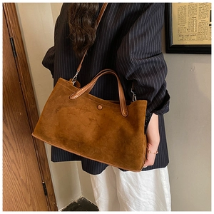 Brown faux suede tote bag shown with elegant blazer and white trousers for a chic look