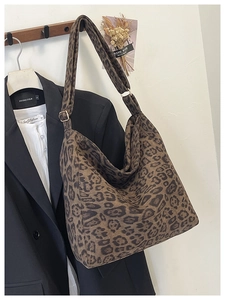Detail view of large leopard print tote bag with adjustable wide strap in a lifestyle setting