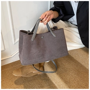 Detail of dark grey suede tote bag with magnetic clasp and detachable strap for daily commute