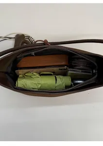 Internal view of the brown leather shoulder bag showing its large capacity and black lining