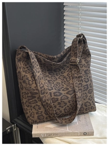 Detail view of leopard print tote bag with adjustable strap and golden metal buckle