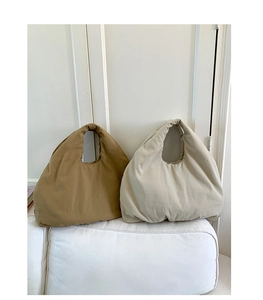 Minimalist canvas tote bags in khaki and beige on a soft sofa in a clean home setting