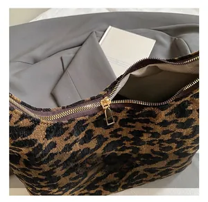 Close-up of golden metal zipper and leopard print fabric on a stylish tote bag