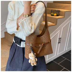 Close-up of leopard print shoulder bag with a cute bear pendant on a staircase