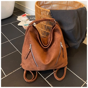 Détail du sac hobo en daim marron avec doubles fermetures éclair et poignée supérieure