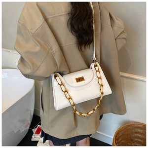 Detail of white glossy leather handbag featuring vintage gold twist lock and chain strap