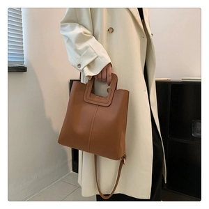 Detailed view of the brown leather tote bag showing smooth texture and fine stitching