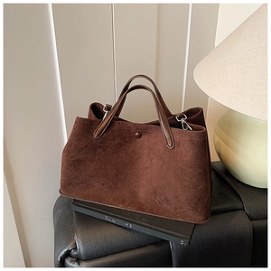 Detail view of the dark brown suede tote bag featuring a matte finish and premium texture