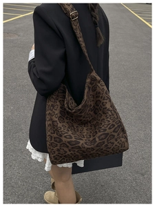 Detail of adjustable metal buckle on a leopard print tote bag with textured fabric