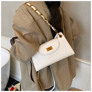 Detail of white glossy chain bag with golden rotary clasp and woven leather shoulder strap