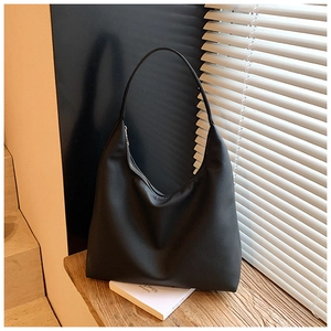 Détail d'un grand sac fourre-tout noir minimaliste en similicuir lisse avec fermeture éclair
