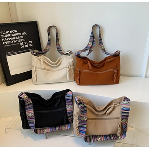 Detail view of corduroy shoulder bags in four colors with ethnic woven straps
