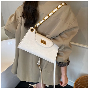 Detail of white textured PU leather bag with gold chain strap and turn-lock buckle