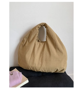 Macro detail showing the khaki fabric texture and pleated finish of this large tote bag